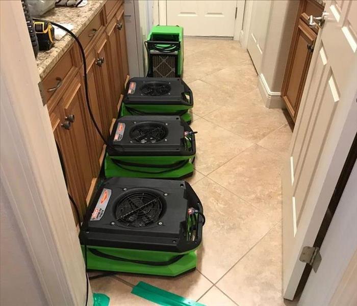 Hallway filled with green SERVPRO air movers. 