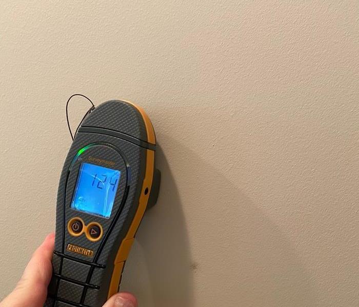 moisture meter up against a wall.