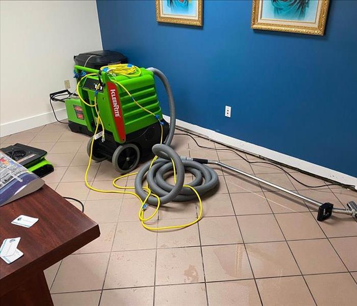 Tile floor with a large green piece of SERVPRO equipment.