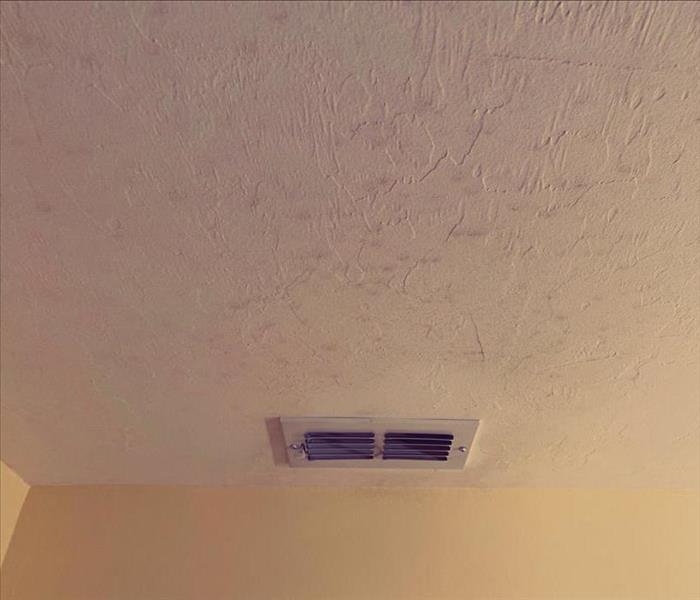 Cream colored ceiling with spots.