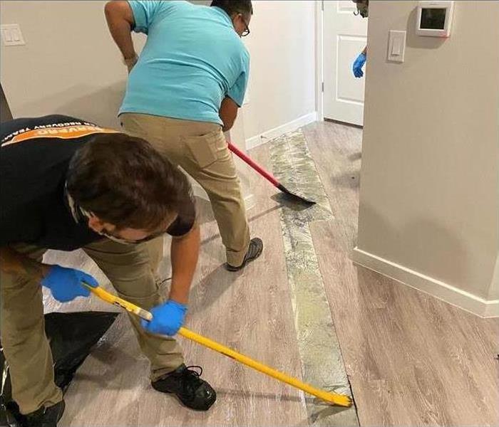Two man removing wood flooring in a home