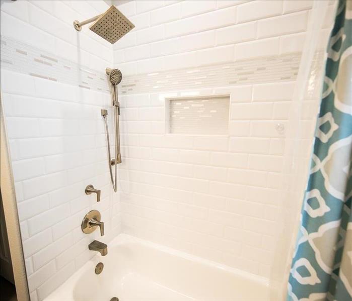 A shower with white tile.